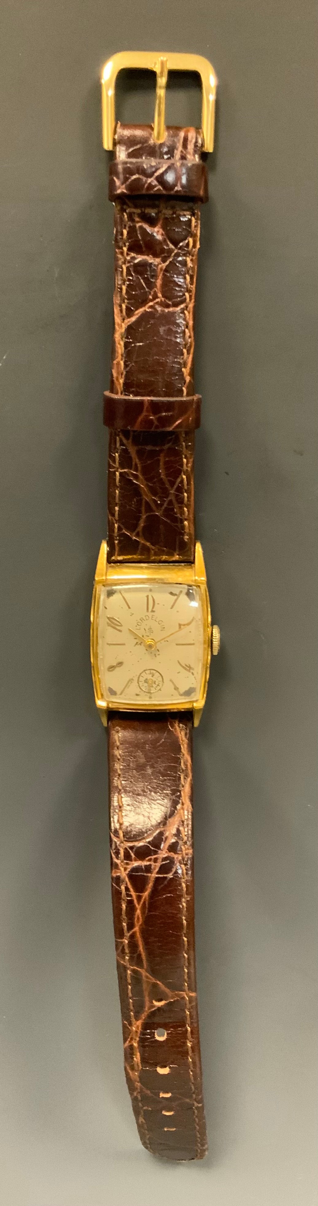 A 1940s Lord Elgin gold plated scallop edge cased wristwatch, silvered dial, Arabic numerals and