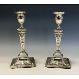 A pair of Edwardian Adam Revival silver candlesticks, embossed in the Neo-Classical taste, 21cm