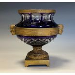 A Continental gilt bronze mounted amethyst glass pedestal vase, Art Deco masks to sides, ribbon-