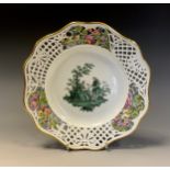 A German porcelain shaped circular plate, decorated with a courting couple, the border pierced and