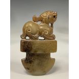 A Chinese carved stone tablet/pendant possibly Hetian Jade, as a foe dog seated above axe head