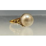 A large cultured pearl ring, creamy grey pearl approx 13mm diameter, unmarked yellow metal shank,