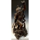 A Japanese hardwood figure, of a warrior in battle with a dragon, 91cm high