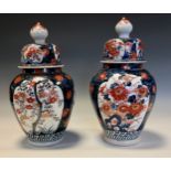 A pair of Japanese ovoid vases and covers, painted in the Imari palette, 29cm high, Meiji period