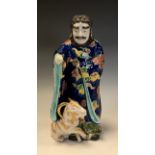 A Japanese porcelain figure, of an elder with a goat, painted in polychrome, 30.5cm high, early 20th