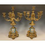 A pair of 19th century French porcelain mounted gilt metal six-light candelabra, cast in the Louis