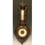 A Black Forest aneroid barometer/thermometer, carved case, cream scale, 69cm high.