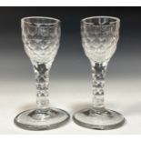 A pair of George III style wine glasses, ovoid bowls, stems engraved overall with printies, circular