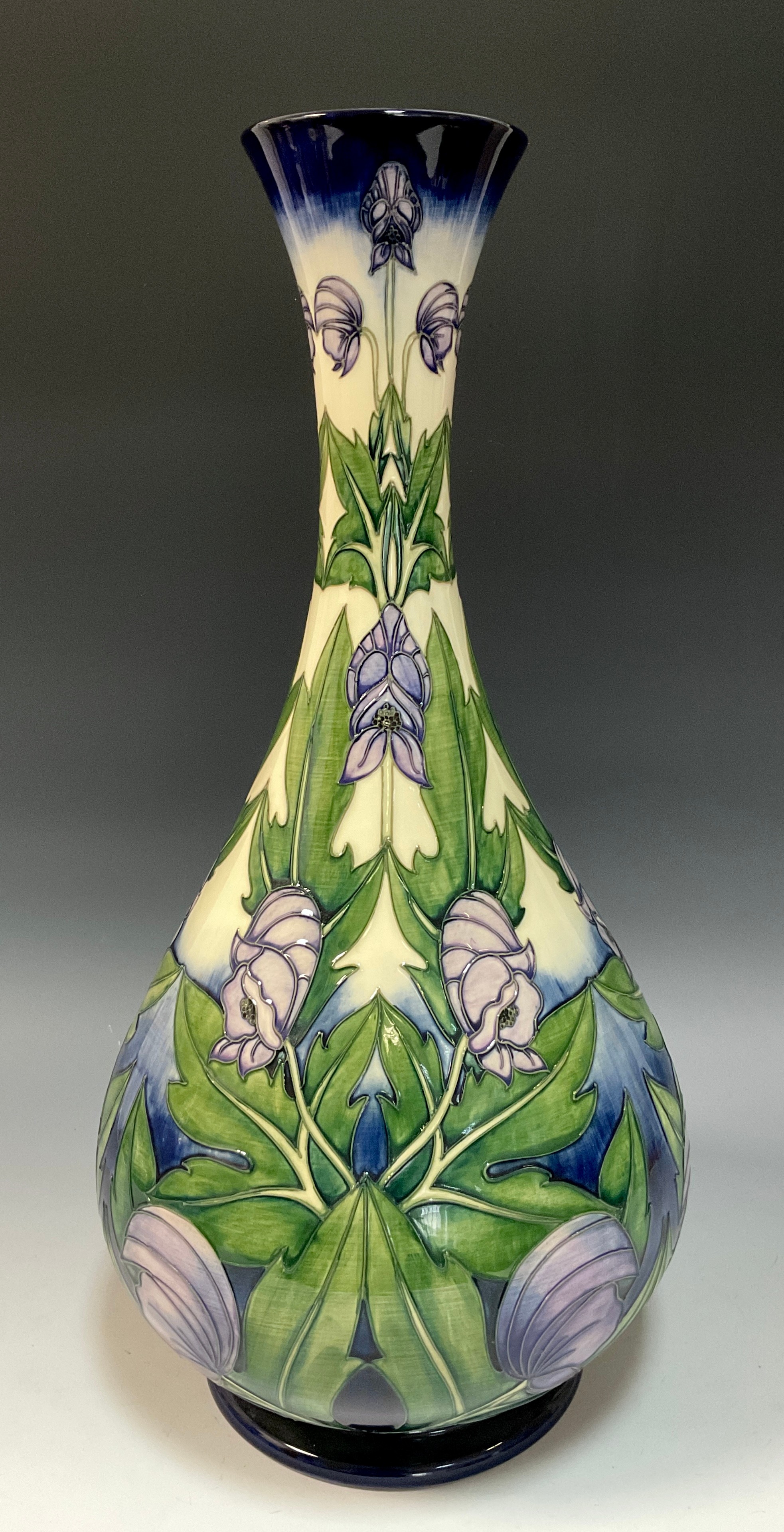 A Moorcroft 'Wolfsbane' vase by Anji Davenport, stylized with tube lined violet flowers on graduated