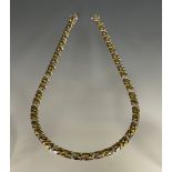A diamond accented two tone 18ct yellow and white gold fancy curb link necklace, set with forty