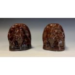 A pair of 19th century treacle glazed window stops or furniture rests, each as the head of a lion,