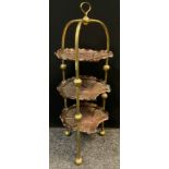 An Edwardian brass and planished copper three tier cake stand, 77cm high x 28cm wide.