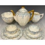A Wileman and Co, ‘Ivy Border' pattern tea service for two, including two fairy shaped tea cups