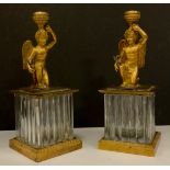 A pair of 19th Century French ormolu and glass cherub candlesticks, each modelled as a kneeling