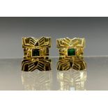 A pair of emerald earrings, each Aztec style shield mount centred with a single square cut