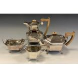 A George V silver four piece tea set, comprising teapot, hot waterpot, milk jug and sugar bowl, of