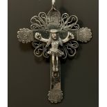 A Colonial silver coloured metal hanging crucifix, possibly African or South American, shaped crest,