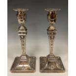 A pair of Victorian silver Neoclassical table candle sticks, embossed with rams heads and urns, West