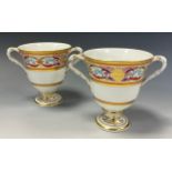 A pair of 19th century English porcelain twin handled cups, with floral painted and gilt scrolling