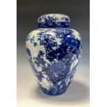 A Japanese ovoid ginger jar, painted in tones of underglaze blue with a bird amongst blossoming
