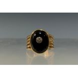 A diamond and black onyx signet ring, oval black onyx cabochon inset with a single round brilliant
