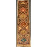 A North west Persian Heriz runner carpet, hand-knotted in earthy tones of red, brown, and cream,