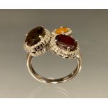 A 14ct gold dress ring set with oval citrine, garnet and smoky quartz stones, each surrounded by