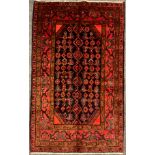 A North west Persian Hamadan rug / carpet, hand-knotted in deep tones of red, brown, and blue, on