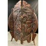 A Chinese carved hardwood modesty screen, the large central circular panel worked in high relief