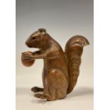 A Novelty tape measure, as a seated Squirrel holding a nut, 5.9cm high.