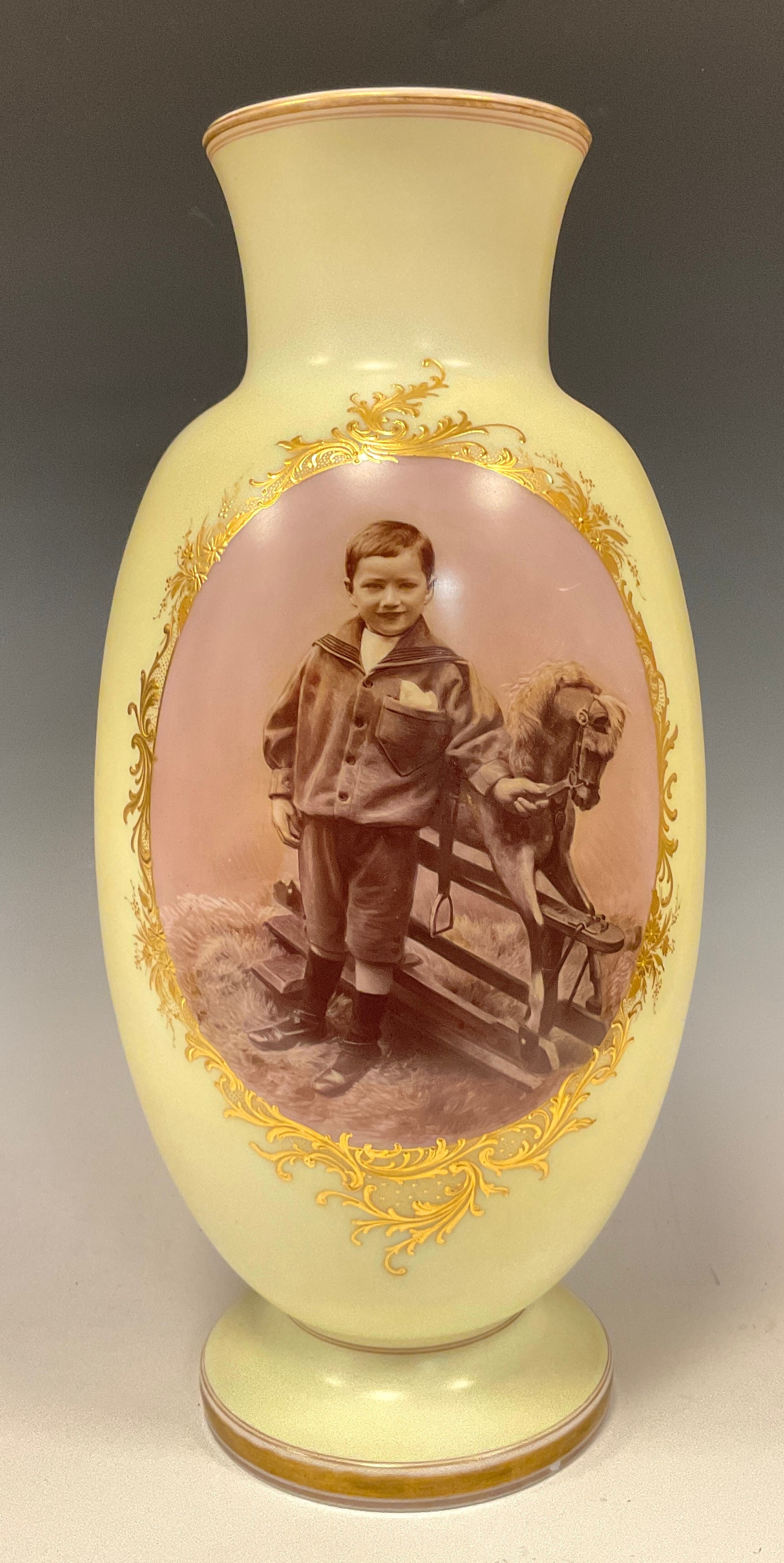 A large Victorian opaque glass vase, with oval photographic panel depicting a boy and rocking horse,