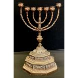 An Indian seven light Menorah candelabrum, three central sconces surrounded by revolving