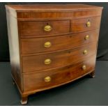 A George IV mahogany bowfront chest, of two short and three long graduated drawers, oval brass