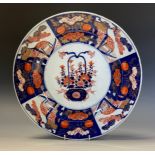 A Japanese Imari dished charger, decorated flowers and landscape panels, the reverse painted with