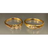 A diamond three stone and gold coloured metal ring; another three stone ring (2)
