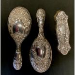 An Edwardian matches silver hand mirror and brush, embossed with fruiting vines and trees,