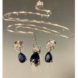 A diamond and sapphire pendant and earring suite, each with a floral cluster of seven diamonds