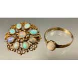 An opal shield brooch, open setting set with nine opal cabochons, scrolled and ball details, stamped