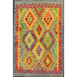 A Turkish Anatolian Kilim rug, knotted in bright colours, with a repeating geometric pattern, in