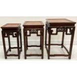 A Chinese stacking nest of three huanghuali occasional tables, panel tops, pierced scroll friezes,