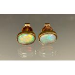 A pair of opal cabochon earrings, flashing green, blue, orange and red colour play, yellow metal