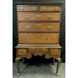 A George III oak chest on stand, swept cornice, pair of short, over three graduated long drawers