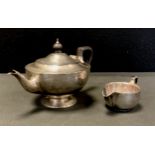 A George V silver teapot, ebony handle, Charles Weale, Birmingham 1920; similar milk jug, William