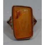 Natural History - an unmarked gold ring, set with an amber specimen containing an insect, the table