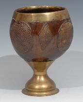 A 19th century brass mounted coconut cup, decorated with alternating hobnail roundels and