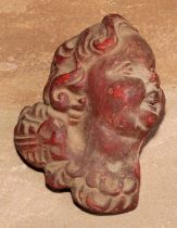 A 19th century wax applique, moulded as the head of a putto, 10cm long