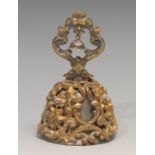 A 19th century gilt metal and enamel table bell, cast and embossed with a profusion of flowers and