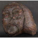 A large folk art burr wood mask, carved as a grotesque face, the features picked out in red pigment,