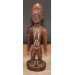 Tribal Art - an African figure, she stands, stylised coiffure, decorated in polychrome pigments,