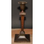 An Adam Revival bronze candlestick, in the Neo-Classical taste with batwing paterae and bell husk